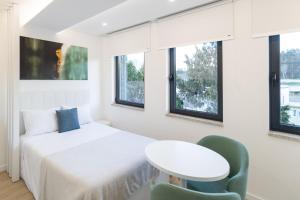 1 dormitorio con 1 cama, mesa y sillas en FAFEL LITTLE HOUSE - Quinta de Cravaz, en Lamego