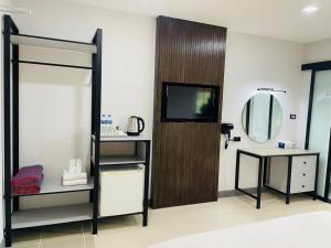a bathroom with a tv and a mirror and a dressing room at Tuana Hotels The Phulin Resort in Karon Beach