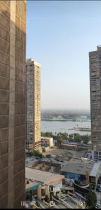 Cette chambre offre une vue sur une ville avec de grands bâtiments et une rivière. dans l'établissement شقة للايجار كورنيش المعادي, au Caire