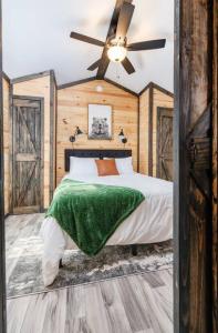 - une chambre avec un lit et un ventilateur de plafond dans l'établissement 3 Bearly Working Luxury Tiny House Firepit Mins to Lake Guntersville, à Guntersville