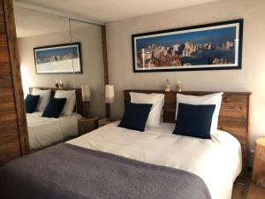 a bedroom with two beds with blue and white pillows at Appartement Le Grand-Bornand, 3 pièces, 6 personnes - FR-1-467-84 in Le Grand-Bornand