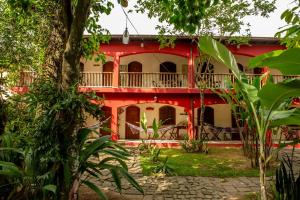 een rood-wit huis met een boom bij Casa da Praia in Paraty