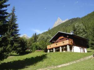 uma casa numa colina com montanhas ao fundo em Grand Chalet au pays du Mont Blanc em Vallorcine