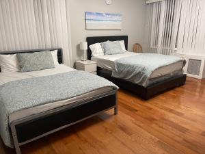 um quarto com 2 camas e piso em madeira em Large 1 Bedroom Apartment in the heart of the Bronx em Unionport