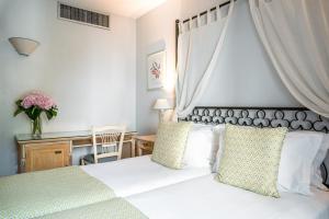 Un dormitorio con una cama blanca con dosel. en Villa Alessandra, en París
