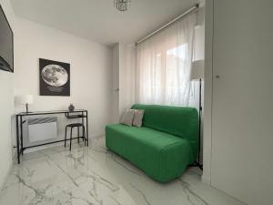 a living room with a green couch and a table at Villa Caterina, Proche Monaco et imprenable vu mer in Beausoleil +9 photos