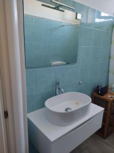 La salle de bains est pourvue d'un lavabo blanc et d'un miroir. dans l'établissement Villa Sole, à Maruggio