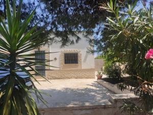 une maison blanche avec une fenêtre et quelques arbres dans l'établissement Villa Sole, à Maruggio