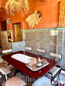 uma sala de jantar com uma mesa vermelha e cadeiras em Atlas Imsker em Marrakech