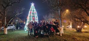 a group of people standing in front of a christmas tree at Stupina in Braşov
