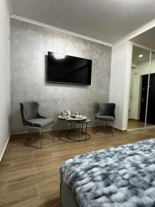 Schlafzimmer mit einem Bett, einem Tisch und einem TV in der Unterkunft Luxury Studio 7 in Roşu