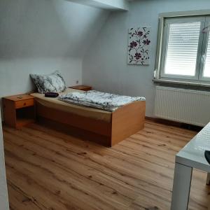 um quarto com uma cama e piso em madeira em Ferienhaus Thüringen em Schwallungen