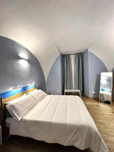 1 dormitorio con 1 cama blanca grande y paredes azules en Nel Vico, en Nápoles