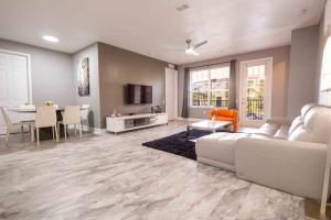 DISNEY PARKS- International Dr - Orlando Luxury Condominium- Fully Equipped - 3bed & 2 bath- في أورلاندو: غرفة معيشة مع أريكة بيضاء وطاولة