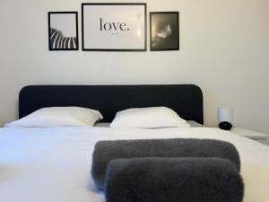 a bedroom with a white bed with a black headboard at Elegante Unterkunft in Stadtnähe in Adliswil