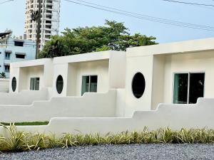 a white building with round windows at Sunvada Beach Rayong in Rayong