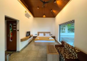 1 dormitorio con 1 cama y 1 sofá en Jai Lake House en Perumbalam
