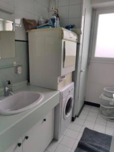 a bathroom with a washing machine and a sink at City Break - Room Chambre Geneva in Annemasse