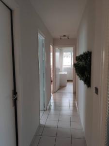 um corredor com piso de azulejo branco numa casa em City Break - Room Chambre Geneva em Annemasse