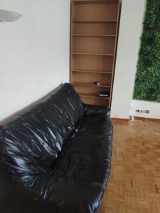 un divano in pelle nera, situato in un soggiorno. di City Break - Room Chambre Geneva ad Annemasse