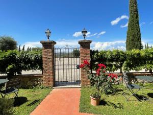 un cancello in ferro battuto con due luci sopra di Agriturismo Castello di Montauto a San Gimignano