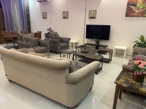 شاليهات أريزو في الرياض: غرفة معيشة مع كنب وتلفزيون بشاشة مسطحة