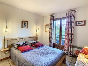 ein Schlafzimmer mit einem Bett mit zwei Kissen und einem Fenster in der Unterkunft Appartement Combloux, 2 pièces, 4 personnes - FR-1-560-20 in Combloux