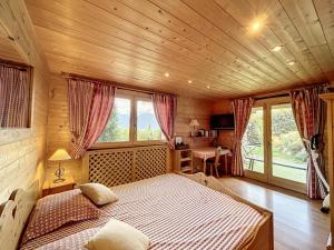 ein Schlafzimmer mit einem großen Bett in einem Holzzimmer in der Unterkunft Chalet Combloux, 5 pièces, 8 personnes - FR-1-560-32 in Combloux