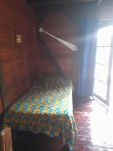 Cama pequeña en habitación con ventana en Charming Yellow Houses studio with terrace en Bocas del Toro