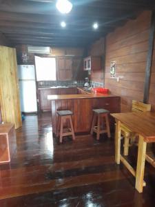 una cocina con encimeras de madera, mesa y taburetes en Charming Yellow Houses studio with terrace en Bocas del Toro
