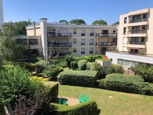un complejo de apartamentos con jardín frente a un edificio en Le Fontenay bleu, en Bourg-la-Reine
