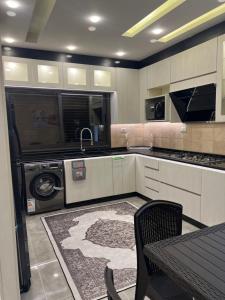 a kitchen with a washer and a sink and a dishwasher at Asia Hotel Apartments in Irbid
