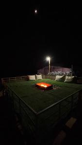 Sunrise Desert Local Private Camp في Badīyah: ملعب بيسبول في الليل مع ضوء عليه