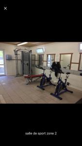 un gimnasio con 2 bicicletas estáticas en una habitación en Mobilhome siblu les charmettes la Palmyre, 17570 Les Mathes, en Les Mathes