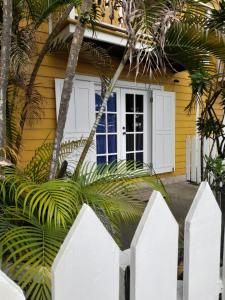 een geel huis met een wit hek ervoor bij Charming Yellow Houses studio with terrace in Bocas del Toro