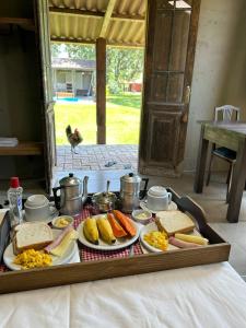 a tray with plates of food on a table at Pousada Charqueada Costa do Abolengo in Pelotas