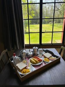 a table with a tray of food on a table at Pousada Charqueada Costa do Abolengo in Pelotas