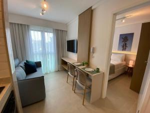 a small apartment with a desk and a bedroom at Green Porto 207 -Flat premium no centro de Porto in Ipojuca