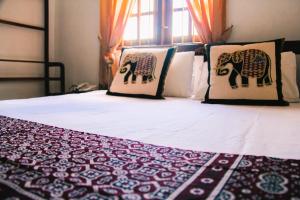 łóżko z dwoma poduszkami i słoniem w obiekcie Muduna Walawwa Resort w mieście Kandy
