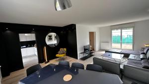 een woonkamer met een bank en een tafel bij Maison Style & Espace à Angers in Angers