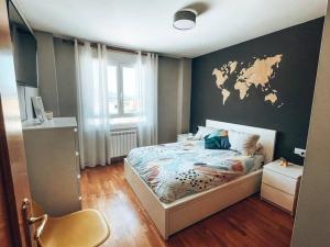 1 dormitorio con 1 cama con mapa en la pared en Apartamento Cemba Ponferrada, en Ponferrada