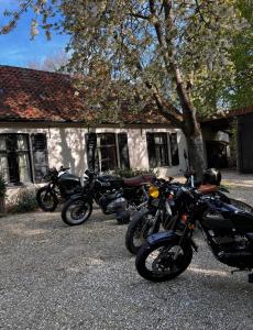 um grupo de motociclos estacionados em frente a uma casa em The cave em Sint-Denijs-Westrem