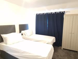 a bedroom with two beds and a blue curtain at Walker Lodge in Oldbury