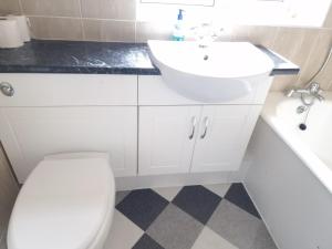 a white bathroom with a sink and a toilet at Walker Lodge in Oldbury