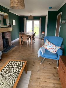 sala de estar con silla azul y mesa en Tenby 2 bed flat with parking, plus pet, en Tenby