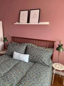 Un dormitorio con una cama con dos cuadros en la pared. en Tenby 2 bed flat with parking, plus pet, en Tenby