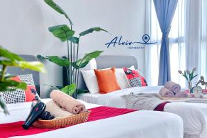 a bedroom with two beds with towels and plants at Atlantis Melaka I 5-11pax I 5min JonkerSt BY Alviv Management in Melaka