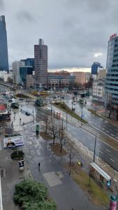 una ciudad con una calle con coches y autobuses en Elegancki apartament w sercu Warszawy en Varsovia