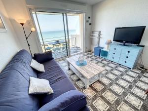 un salon avec un canapé bleu et une télévision dans l'établissement Appartement Jullouville, 2 pièces, 4 personnes - FR-1-361-360, à Jullouville