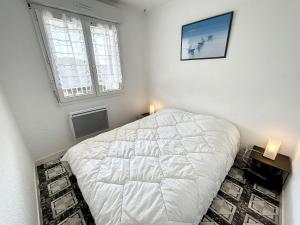 - une chambre avec un lit blanc et 2 fenêtres dans l'établissement Appartement Jullouville, 2 pièces, 4 personnes - FR-1-361-360, à Jullouville